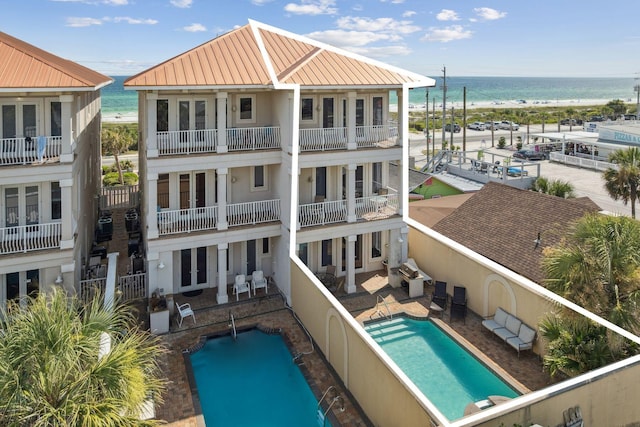 19108 Front Beach Rd Unit B, Panama City Beach, FL 32413 - rear view of house featuring view of water and beach, french doors, an outdoor pool, and stucco siding