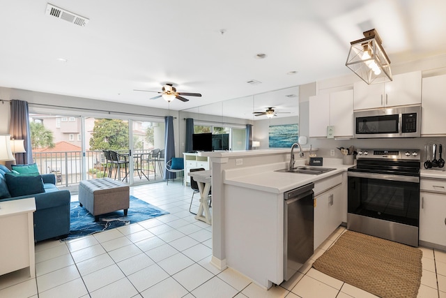 2606 Scenic Gulf Dr Unit 4206, Miramar Beach, FL 32550 - kitchen featuring stainless steel appliances, open floor plan, a peninsula, a ceiling fan, and light tile patterned flooring