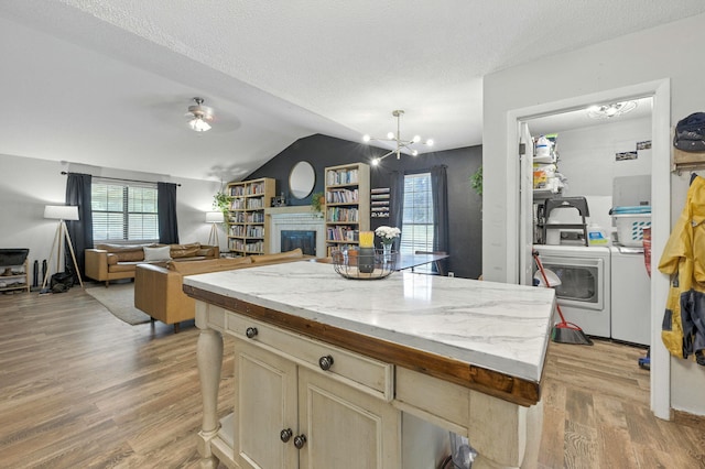 3774 Laird Rd, Crestview, FL 32539 - kitchen with independent washer and dryer, a chandelier, light wood finished floors, lofted ceiling, and a fireplace