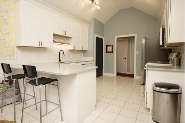 1262 Whitewood Way, Niceville, FL 32578 - kitchen with a peninsula, decorative backsplash, light countertops, white cabinetry, and a breakfast bar