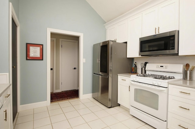 1262 Whitewood Way, Niceville, FL 32578 - kitchen with appliances with stainless steel finishes, vaulted ceiling, light countertops, white cabinets, and light tile patterned floors