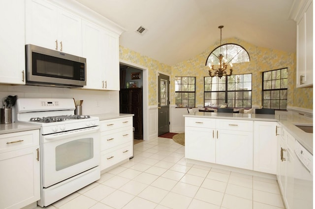 1262 Whitewood Way, Niceville, FL 32578 - kitchen with white appliances, wallpapered walls, a peninsula, a chandelier, and light countertops
