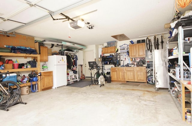 1262 Whitewood Way, Niceville, FL 32578 - garage with freestanding refrigerator, a garage door opener, and a workshop area