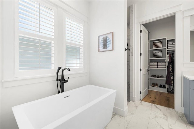 133 E Firethorn Cir, Inlet Beach, FL 32461 - bathroom featuring marble look tile flooring, a walk in closet, a freestanding bath, and vanity