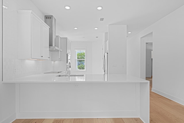 128 Ravine Rd, Watersound, FL 32461 - kitchen with wall chimney exhaust hood, freestanding refrigerator, light countertops, a peninsula, and recessed lighting