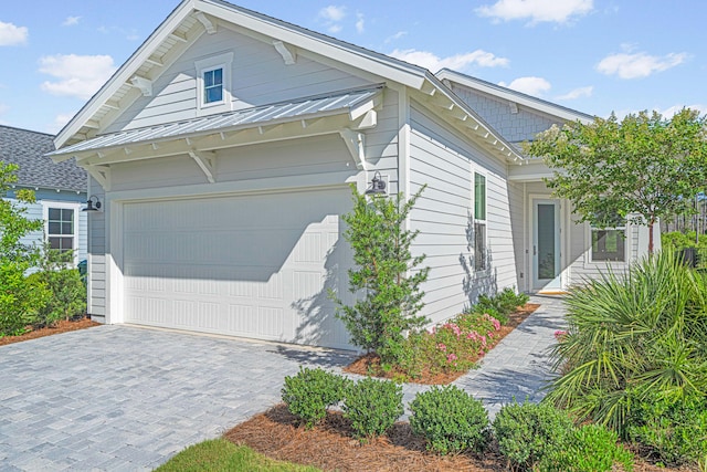128 Ravine Rd, Watersound, FL 32461 - view of side of property with decorative driveway, a metal roof, and a garage