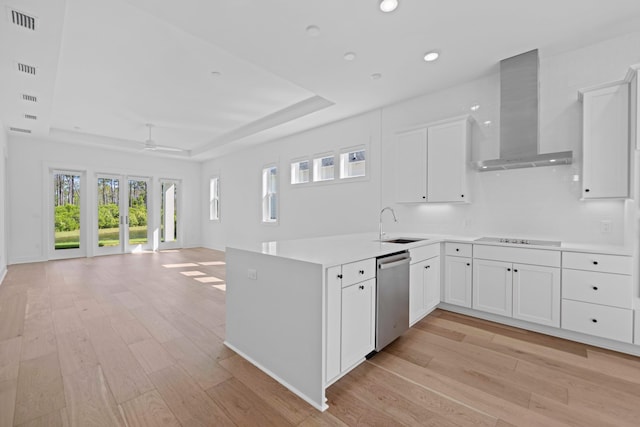 128 Ravine Rd, Watersound, FL 32461 - kitchen featuring stainless steel dishwasher, wall chimney exhaust hood, a tray ceiling, light wood-style flooring, and open floor plan