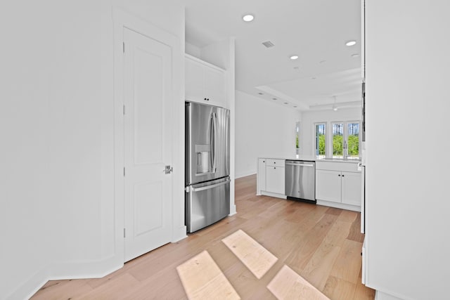 128 Ravine Rd, Watersound, FL 32461 - kitchen featuring stainless steel appliances, white cabinets, recessed lighting, light wood finished floors, and a peninsula