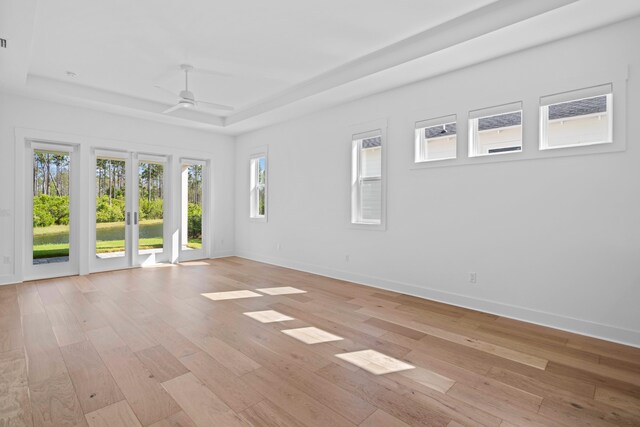 128 Ravine Rd, Watersound, FL 32461 - empty room with a tray ceiling, ceiling fan, and light wood-style floors