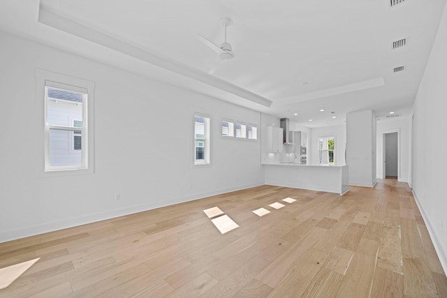 128 Ravine Rd, Watersound, FL 32461 - unfurnished living room featuring a raised ceiling, light wood finished floors, ceiling fan, and recessed lighting