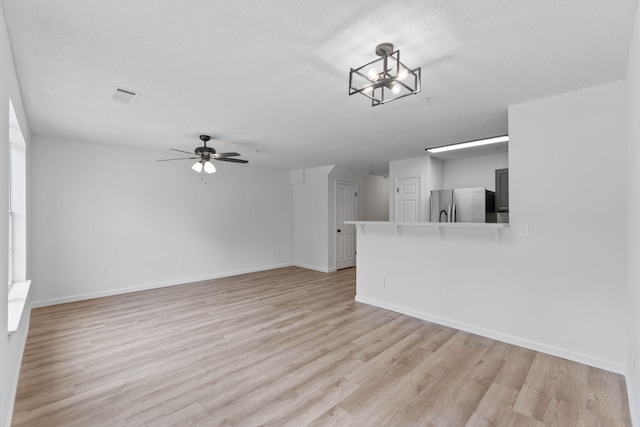 222 Swaying Pine Ct, Crestview, FL 32539 - unfurnished living room with light wood finished floors, a ceiling fan, and a chandelier
