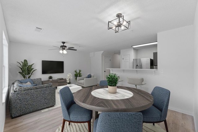 222 Swaying Pine Ct, Crestview, FL 32539 - dining space with light wood-style flooring, ceiling fan, and a chandelier