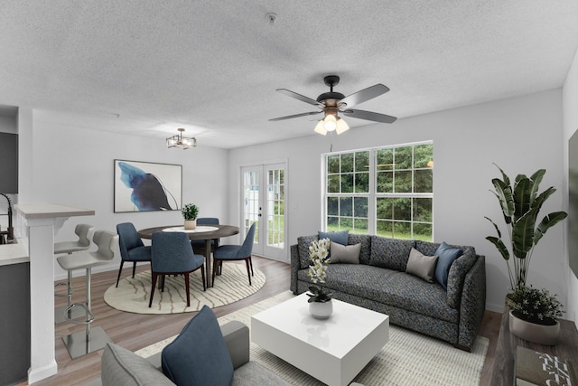 222 Swaying Pine Ct, Crestview, FL 32539 - living room featuring french doors, light wood-type flooring, a textured ceiling, and a ceiling fan