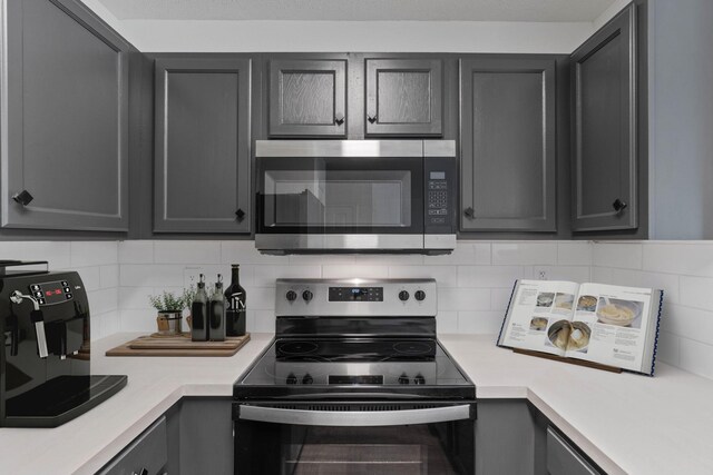 222 Swaying Pine Ct, Crestview, FL 32539 - kitchen with appliances with stainless steel finishes, light countertops, gray cabinetry, and backsplash