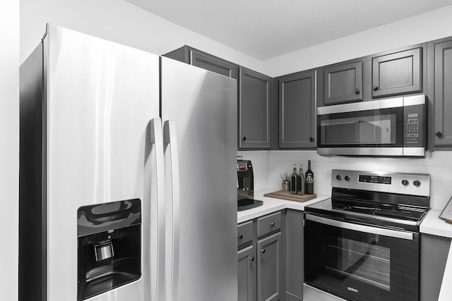 222 Swaying Pine Ct, Crestview, FL 32539 - kitchen featuring stainless steel appliances, gray cabinetry, light countertops, and decorative backsplash