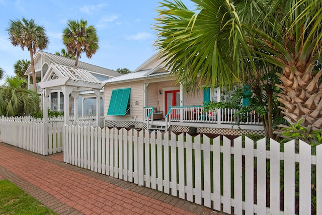 4460 Ocean View Dr, Destin, FL 32541 - view of front of home with a metal roof, a fenced front yard, and a deck