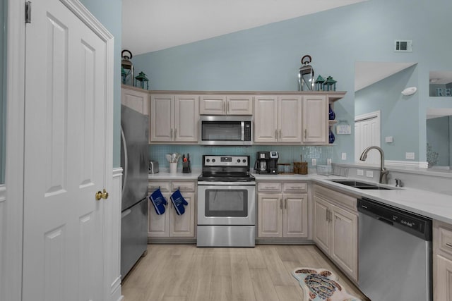 4460 Ocean View Dr, Destin, FL 32541 - kitchen featuring appliances with stainless steel finishes, light countertops, tasteful backsplash, light wood-type flooring, and lofted ceiling