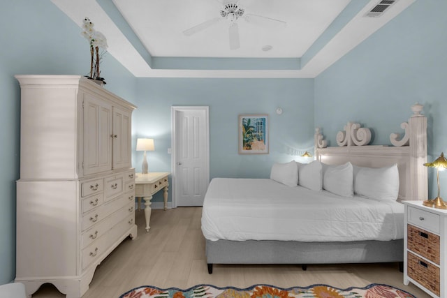 4460 Ocean View Dr, Destin, FL 32541 - bedroom with a tray ceiling, light wood-style flooring, and a ceiling fan