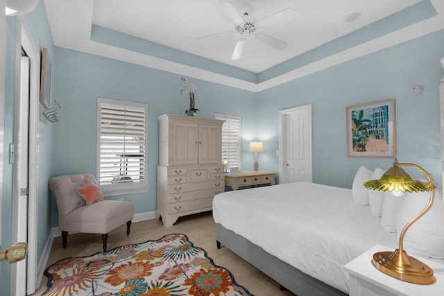 4460 Ocean View Dr, Destin, FL 32541 - bedroom featuring a ceiling fan, light wood-style floors, and a raised ceiling