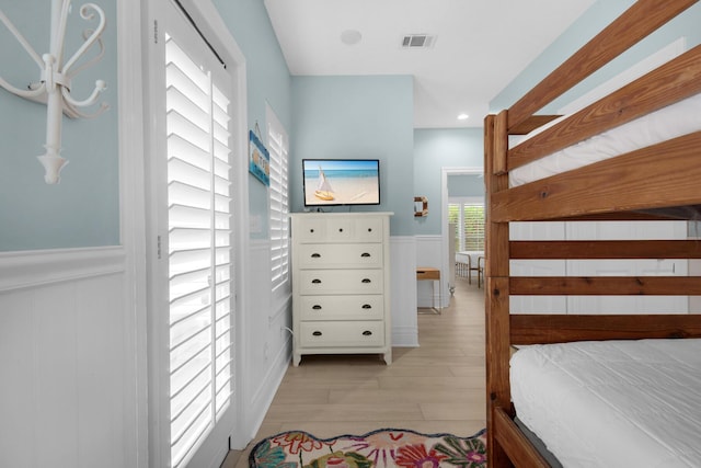 4460 Ocean View Dr, Destin, FL 32541 - bedroom with wood finished floors, wainscoting, and a decorative wall