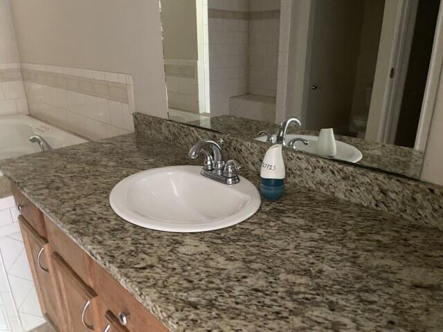 159 Michigan Ln, Defuniak Springs, FL 32433 - bathroom featuring vanity, tile patterned flooring, and a tub to relax in