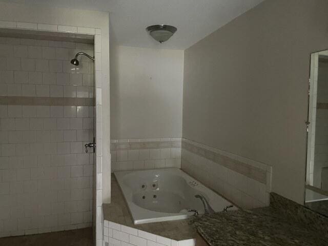 159 Michigan Ln, Defuniak Springs, FL 32433 - bathroom featuring a tile shower and a tub with jets