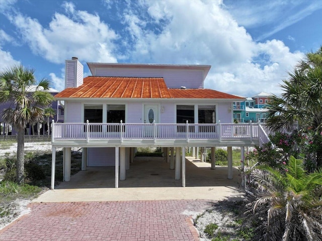 8147 White Sands Blvd, Navarre, FL 32566 - view of front facade featuring a carport, decorative driveway, and a chimney
