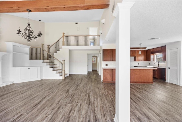 8147 White Sands Blvd, Navarre, FL 32566 - unfurnished living room featuring dark wood finished floors, a high ceiling, stairway, and a chandelier
