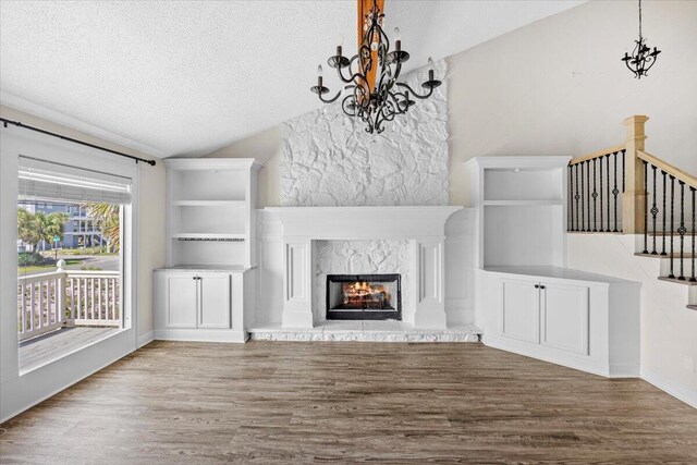 8147 White Sands Blvd, Navarre, FL 32566 - unfurnished living room with lofted ceiling, wood finished floors, a textured ceiling, stairs, and a chandelier