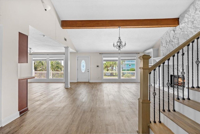 8147 White Sands Blvd, Navarre, FL 32566 - foyer featuring healthy amount of natural light, ornate columns, stairs, light wood-style flooring, and beam ceiling