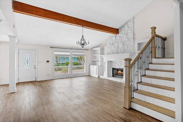 8147 White Sands Blvd, Navarre, FL 32566 - unfurnished living room with wood finished floors, a high end fireplace, stairway, and a chandelier