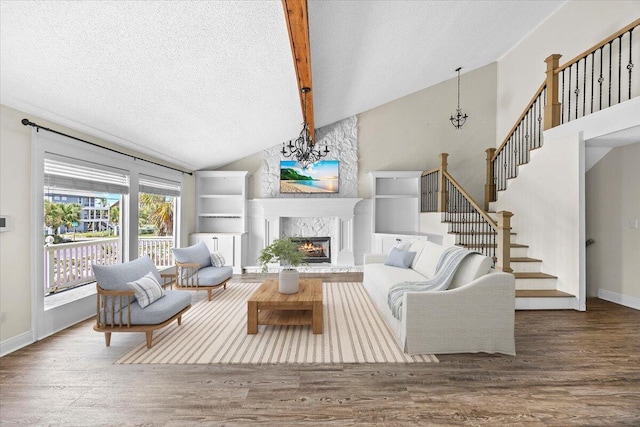 8147 White Sands Blvd, Navarre, FL 32566 - living room with wood finished floors, a textured ceiling, a large fireplace, beamed ceiling, and stairway
