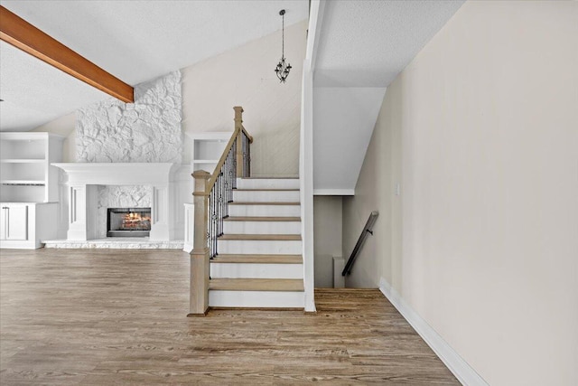 8147 White Sands Blvd, Navarre, FL 32566 - staircase with wood finished floors, a textured ceiling, and a fireplace