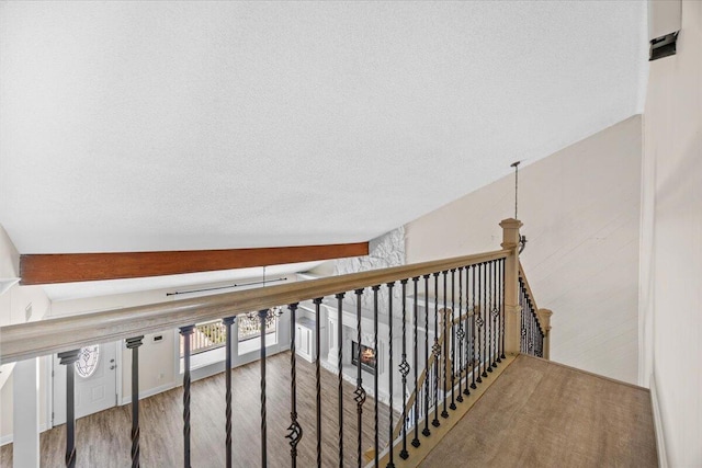 8147 White Sands Blvd, Navarre, FL 32566 - corridor with wood finished floors, a textured ceiling, and an upstairs landing