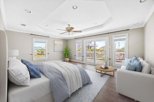 8147 White Sands Blvd, Navarre, FL 32566 - bedroom featuring a raised ceiling, access to outside, wood finished floors, multiple windows, and a textured ceiling