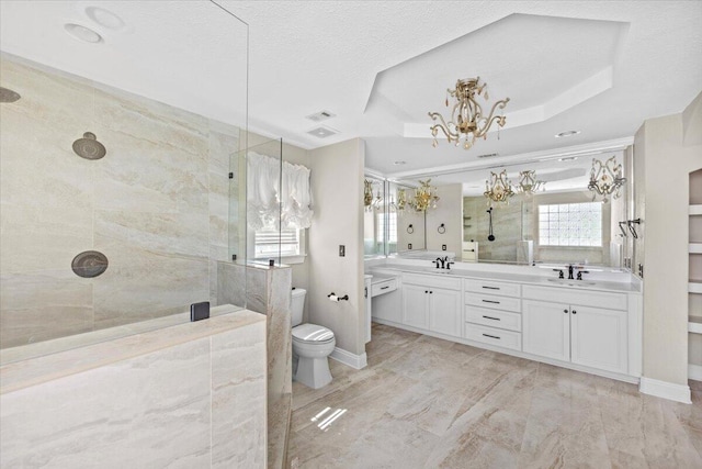 8147 White Sands Blvd, Navarre, FL 32566 - bathroom with tiled shower, double vanity, a chandelier, a textured ceiling, and a tray ceiling