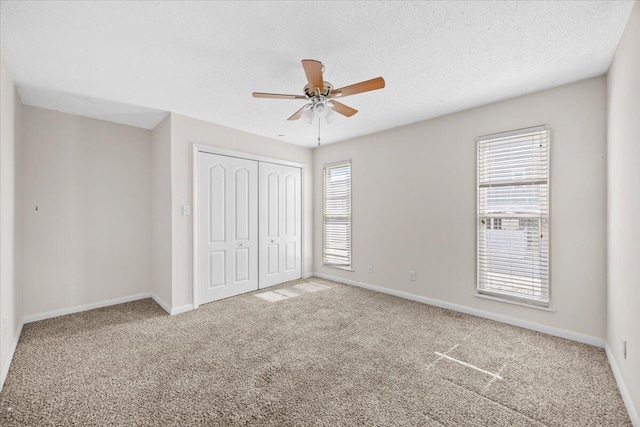 8147 White Sands Blvd, Navarre, FL 32566 - unfurnished bedroom with a closet, carpet flooring, a ceiling fan, and a textured ceiling