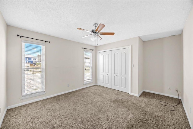 8147 White Sands Blvd, Navarre, FL 32566 - unfurnished bedroom featuring carpet flooring, multiple windows, a closet, and a textured ceiling