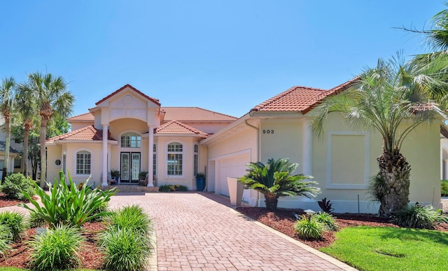 503 Regatta Bay Blvd, Destin, FL 32541 - mediterranean / spanish-style home with french doors, a garage, decorative driveway, and a tiled roof