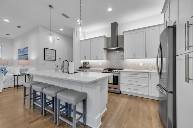 22 Cypress Rdg, Santa Rosa Beach, FL 32459 - kitchen featuring wall chimney range hood, appliances with stainless steel finishes, tasteful backsplash, a breakfast bar, and light countertops