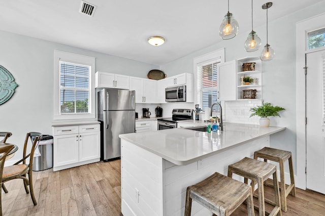 198 Somerset Bridge Rd Unit 143, Santa Rosa Beach, FL 32459 - kitchen featuring stainless steel appliances, a peninsula, light countertops, a breakfast bar, and white cabinets