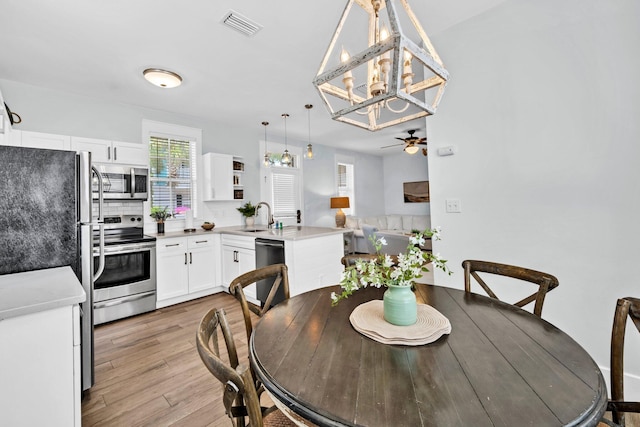 198 Somerset Bridge Rd Unit 143, Santa Rosa Beach, FL 32459 - dining room with light wood-type flooring, a chandelier, and ceiling fan