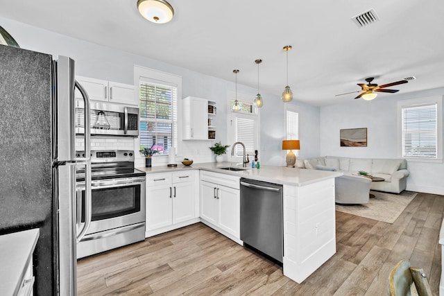 198 Somerset Bridge Rd Unit 143, Santa Rosa Beach, FL 32459 - kitchen with stainless steel appliances, a peninsula, light wood-type flooring, open floor plan, and white cabinets