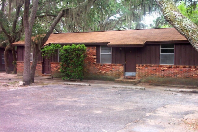 947 Don Dr, Fort Walton Beach, FL 32547 - ranch-style home with brick siding, uncovered parking, board and batten siding, and a shingled roof