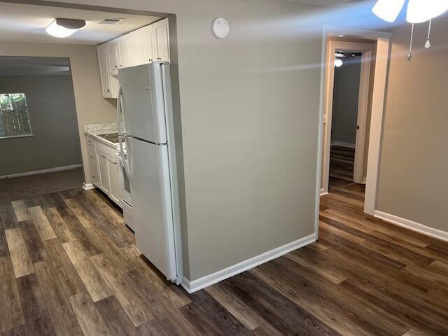 947 Don Dr, Fort Walton Beach, FL 32547 - kitchen with freestanding refrigerator, white cabinetry, dark wood finished floors, and light countertops