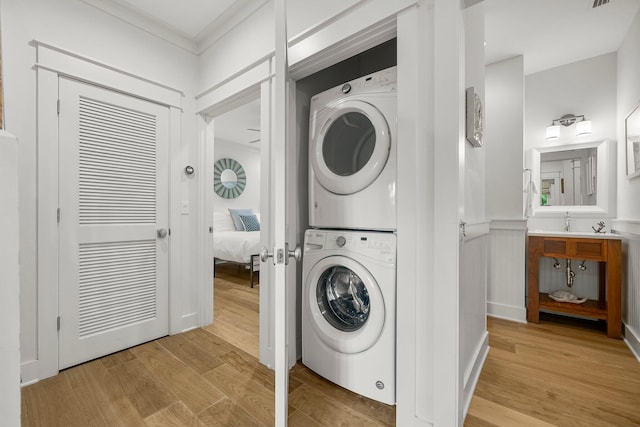499 Patina Blvd, Inlet Beach, FL 32461 - washroom featuring estacked washer and dryer, light wood-type flooring, ornamental molding, and wainscoting