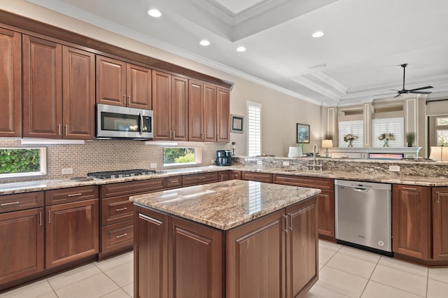 6341 Augusta Cv, Destin, FL 32541 - kitchen featuring stainless steel appliances, light tile patterned floors, a tray ceiling, ornamental molding, and light stone counters
