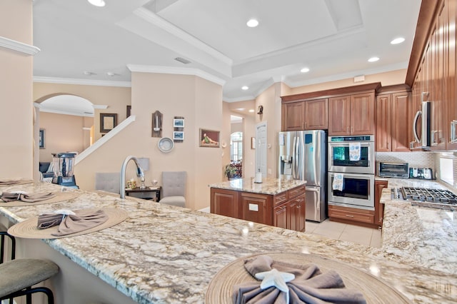 6341 Augusta Cv, Destin, FL 32541 - kitchen with stainless steel appliances, light stone countertops, brown cabinetry, recessed lighting, and decorative backsplash