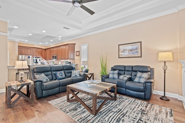 6341 Augusta Cv, Destin, FL 32541 - living room with a tray ceiling, light wood finished floors, crown molding, ceiling fan, and recessed lighting