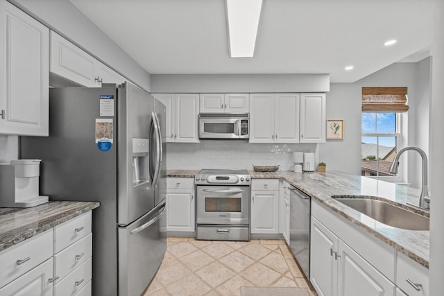 164 Blue Lupine Way Unit 411, Santa Rosa Beach, FL 32459 - kitchen with stainless steel appliances, white cabinets, light stone counters, recessed lighting, and tasteful backsplash